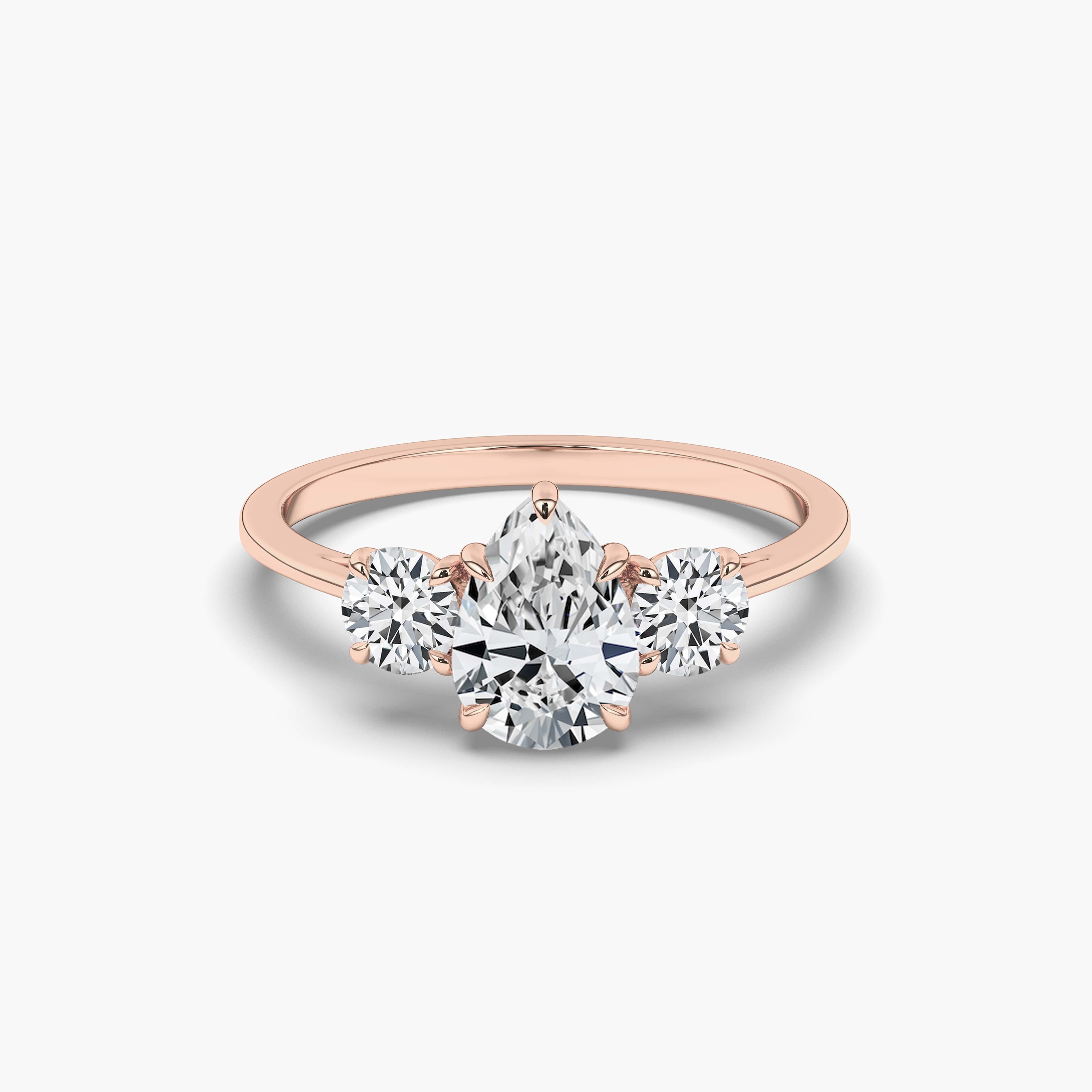 THREE-STONE ENGAGEMENT RING SET IN ROSE GOLD WITH PEAR CUT SIDE STONES