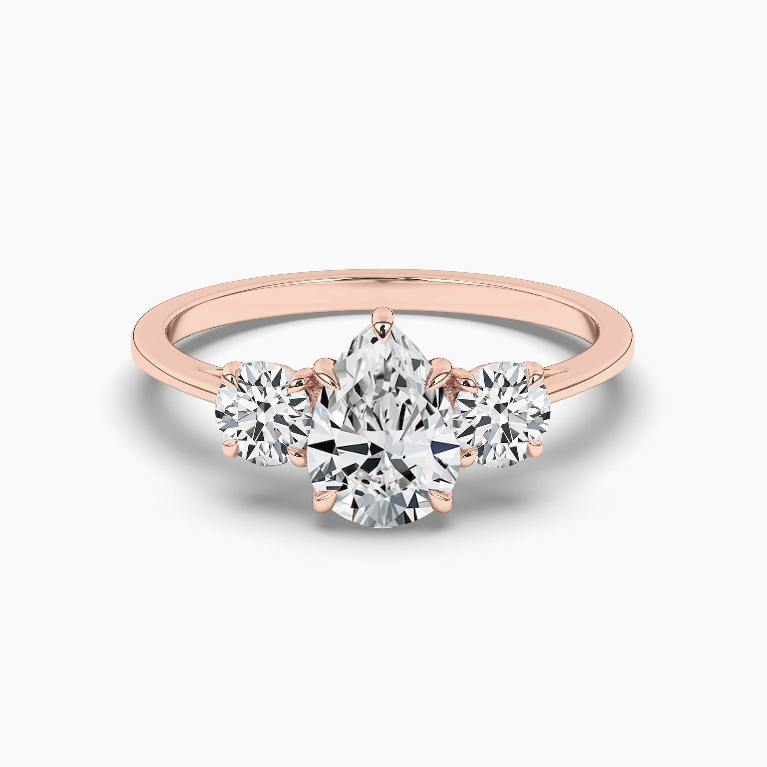 THREE-STONE ENGAGEMENT RING SET IN ROSE GOLD WITH PEAR CUT SIDE STONES