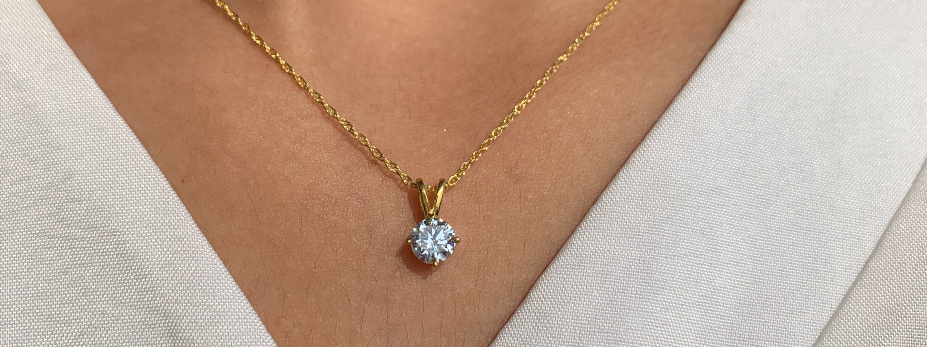 She is wearing round diamond solitaire necklace
